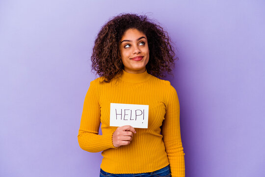 Young African American woman holding a Help placard isolated on purple background dreaming of achieving goals and purposes