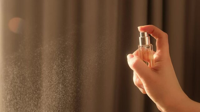 Hand spraying dust perfume, Slow motion. Applies perfume. Spraying fragrance with scent.