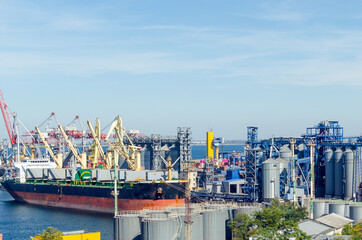 Port cargo crane loads a container onto a cargo ship in a seaport