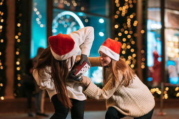 Girls fight for a gift on the street. Friends fun on the street