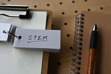 On the punching board there is a clipboard, a notebook, and a word book with the word STEM written...