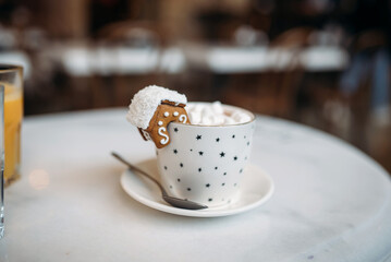 The mug with the christmas decorations and cookie on edge