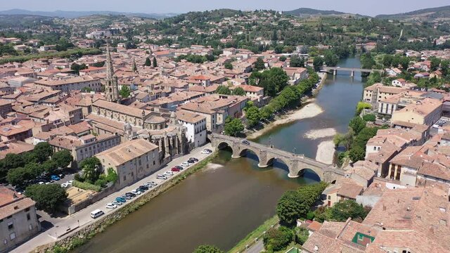 Scenic aerial view of French commune of Limoux on Aude River overlooking gothic spire of Church of Saint Martin in summer, Occitanie 