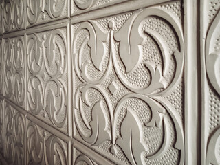 Beige vintage plaster ornament with floral elements close-up. Wall decoration concept. Vintage background.