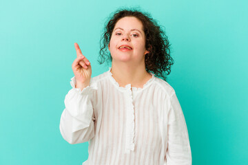 Woman with Down syndrome isolated indicates with both fore fingers up showing a blank space.