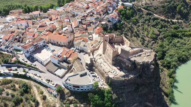 View from drone of Cofrentes cityscape and medieval castle on mountain plain at confluence of Jucar and Cabriel rivers on sunny fall day, Valencia, Spain