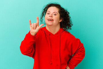 Woman with Down syndrome isolated showing rock gesture with fingers