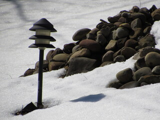 Solar light and garden rocks in snow 