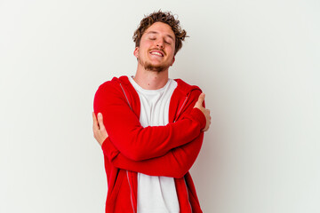 Young caucasian man isolated on white background hugs, smiling carefree and happy.