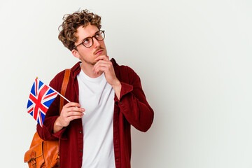 Obraz premium Young student man learning english isolated on white background looking sideways with doubtful and skeptical expression.