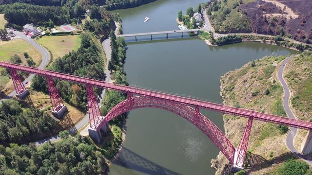 Picturesque summer landscape of Truyere river with Garabit Viaduct, French railway arched viaduct in Cantal department