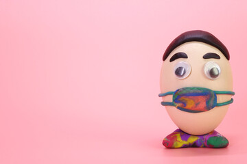 Funny Easter eggs wearing  face mask for Easter holidays decoration with Corona virus (COVID-19) protection concepts