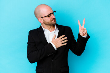 Young business caucasian bald man isolated on blue background taking an oath, putting hand on chest.