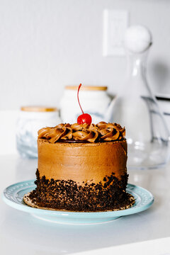 Birthday cake with chocolate frosting and cherry decoration