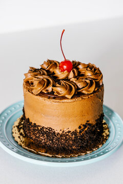 Birthday cake with chocolate frosting and cherry decoration