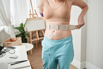Woman adjusting her bandage at the stomach
