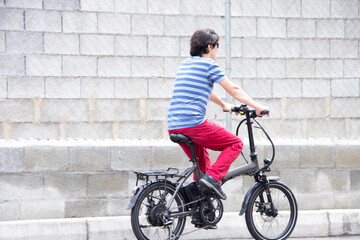 Fototapeta na wymiar Man driving electric bike to work with dark sunglasses