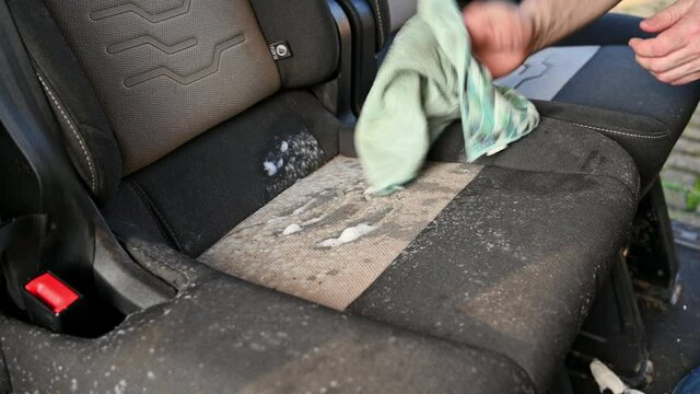 Cleaning solution is rubbed into mold on a car seat that has been laid up for several months