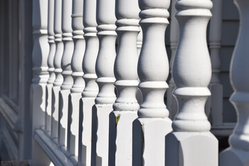 Detail of a row of turned wooden balustrade poles painted white