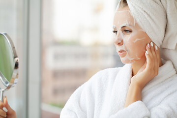 Pretty girl wearing face care mask at home