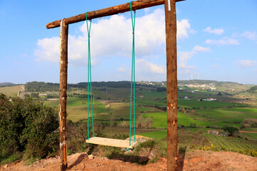 Homemade empty rope swing  against the backdrop of the picturesque nature of Portugal.