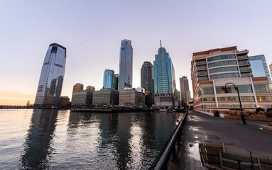 Obraz premium Jersey City, NJ - USA - Feb. 27, 2021: Landscape view of Jersey City's waterfront financial district, Exchange Place at sunset.