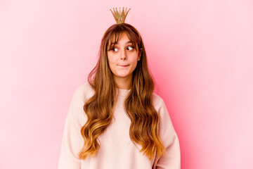 Young caucasian woman with princess crown isolated confused, feels doubtful and unsure.