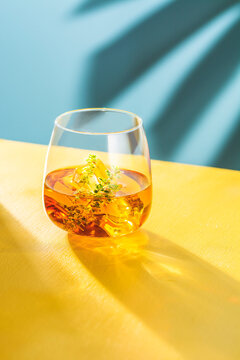 Whiskey glass with ice cubes and thyme