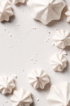 Meringues of different shapes, placed on a white background with negative space for text.