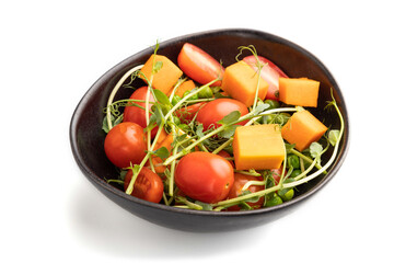 Vegetarian vegetable salad of tomatoes, pumpkin, microgreen pea sprouts isolated on white background. Side view.