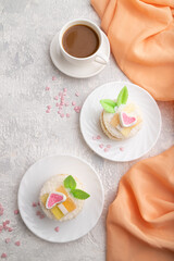 Decorated cake with milk and coconut cream with cup of coffee on a gray concrete background. top view.