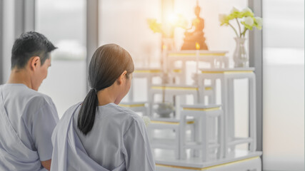 religious buddhist asian couple in white clothing worship and pray to buddha