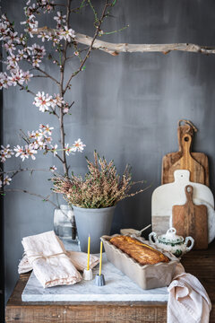 A cake in a tin on a marble counter in a rustic kitchen