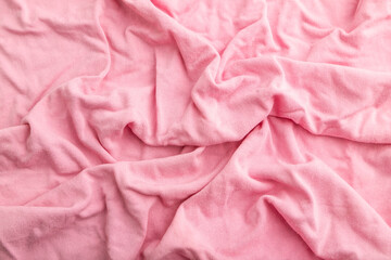 Fragment of pink cotton tissue. Top view, natural textile background.