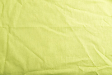 Fragment of smooth green linen tissue. Top view, natural textile background.