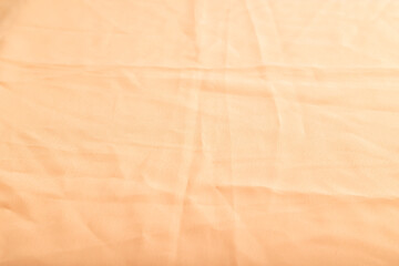 Fragment of smooth orange linen tissue. Side view, natural textile background.