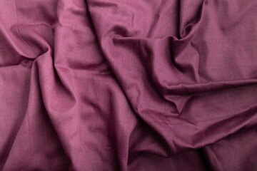 Fragment of cotton purple tissue. Top view, natural textile background.