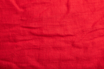 Fragment of smooth red linen tissue. Top view, natural textile background.