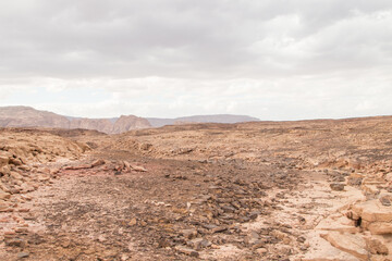 Desert, red mountains, rocks and cloudy sky. Egypt, color canyon.
