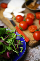 Cherry tomatoes, mix salad, spices, white cheese. Ingredients for making a healthy salad. Healthy food concept.