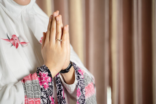 A Muslim woman wearing moslem clothes with hijab and rosary, praying in the mosque, Muslim woman raising hand pray. 