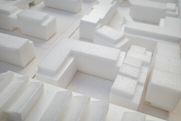 Selective focus, white architectural models. Architect's design thinking process. Urban planning model. Architecture studio working area on table.