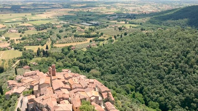 View of a village in tuscany from the drone. Panu up to reveal nature and beautiful sky