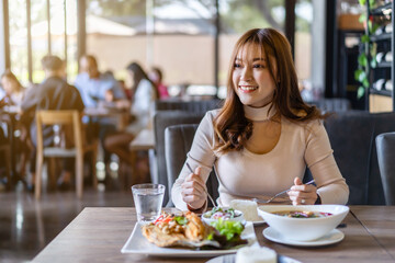 woman eating with food in restaurant