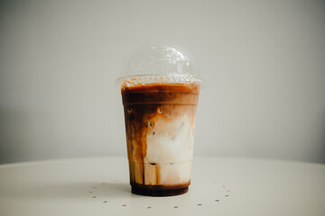 Fresh iced coffee with milk on white table.