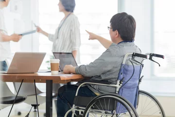 Fotobehang オフィスで働く車椅子の男性 © japolia