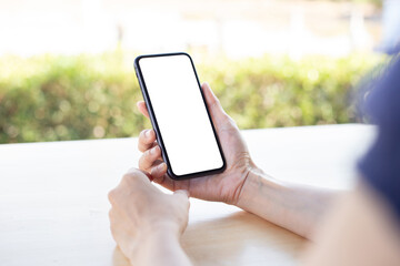 cell phone blank white screen mockup.woman hand holding texting using mobile on desk at...