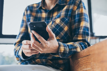 using cell phone hand holding mobile texting message contact us.chatting,search internet information in office.technology device communication connecting