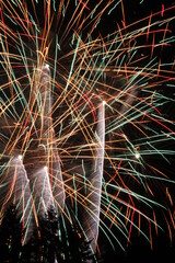 Multiple exploding fireworks thrashing the night sky
