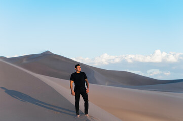 Man in black alone in white desert sand dunes